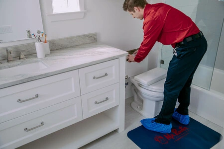 Mr. Rooter tech repairing toilet