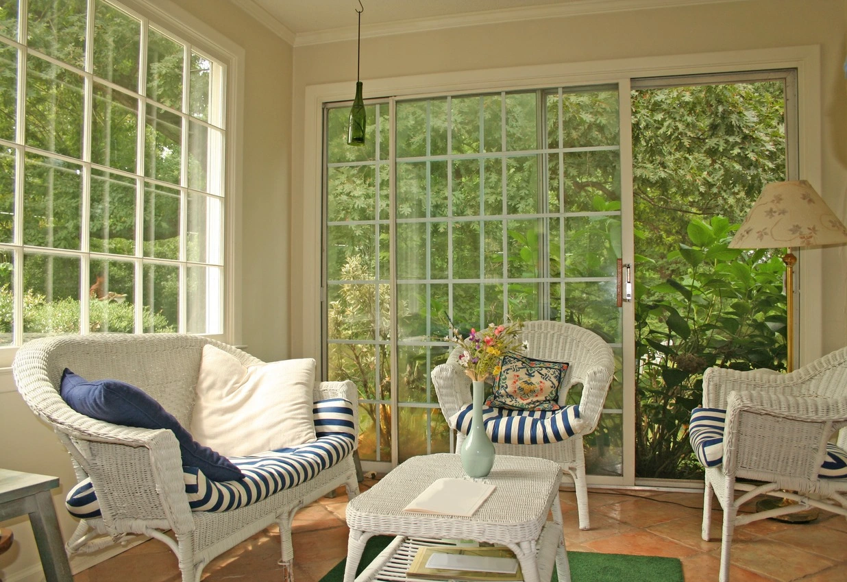 Bright and airy sunroom with wicker furniture.