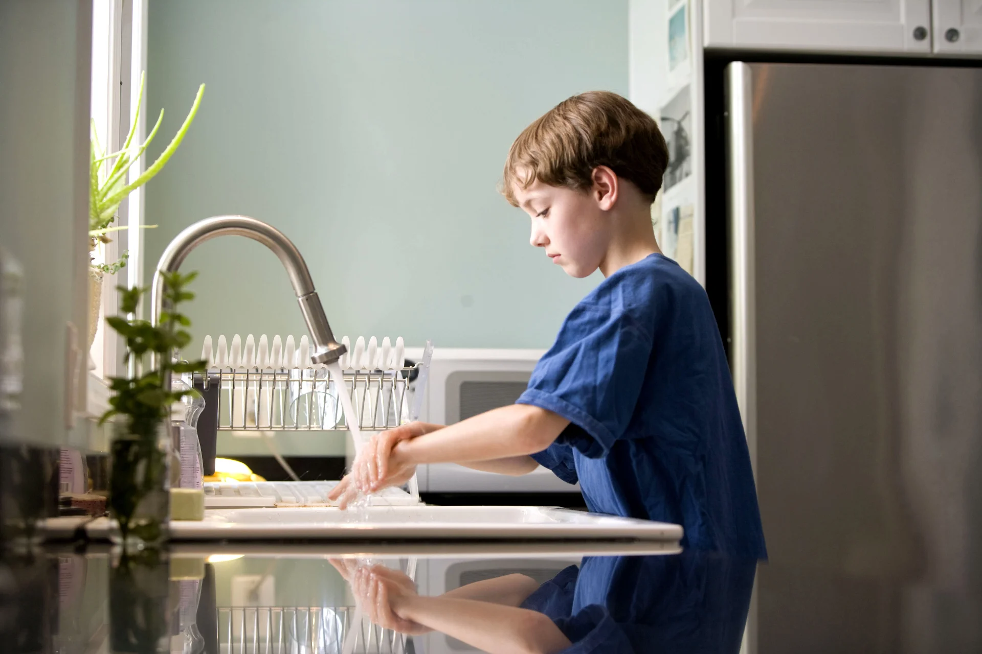 young boy washing hands