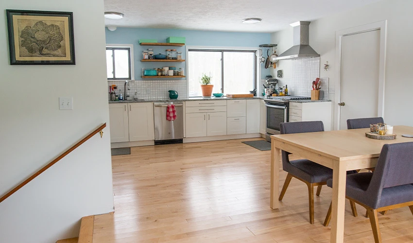 White modern eat-in kitchen with stairs leading down