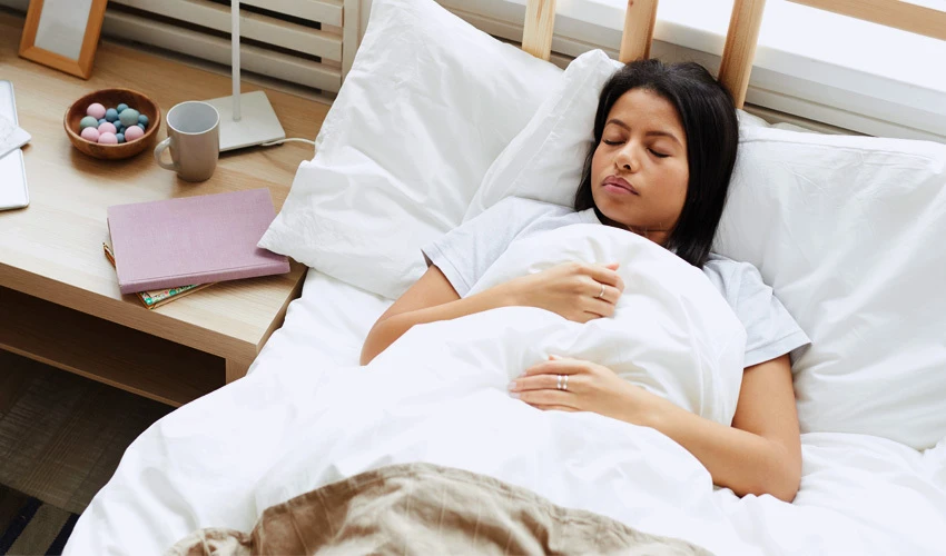 woman sleeping in bed with white sheets