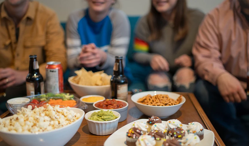 group of people sitting at party with snacks