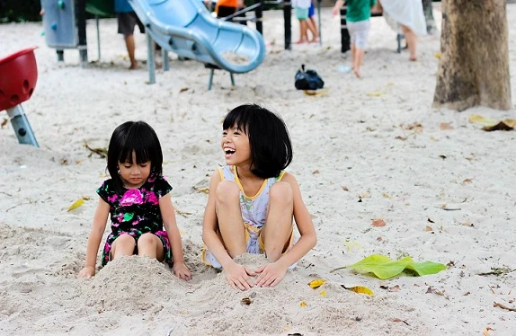 two kids on a sandy playground