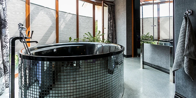 glass tiled soaking tub in modern bathroom