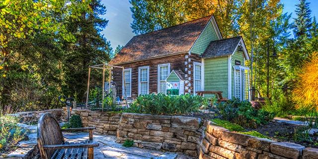 tiny log home with low stone border wall