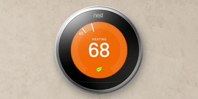 nest thermostat with orange face set to 68 degrees