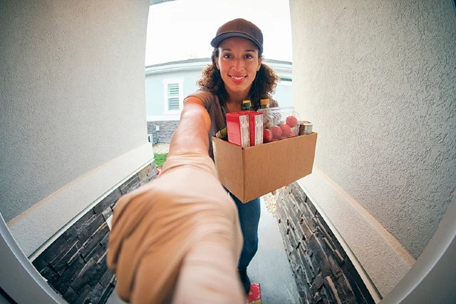 delivery person at front door ringing smart doorbell