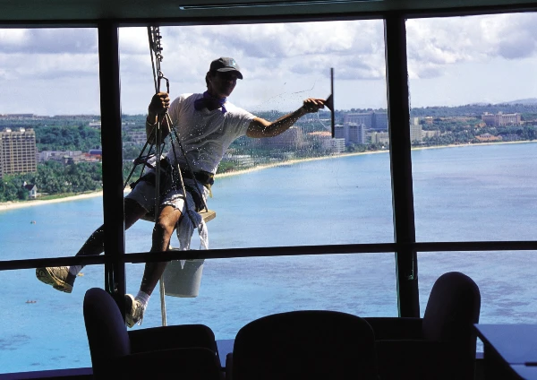 Tethered man cleaning a window