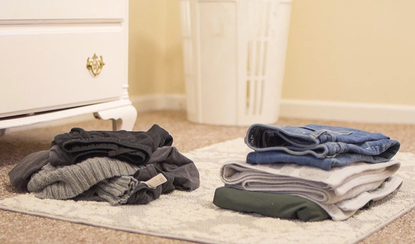 Folded clothes piled on the floor