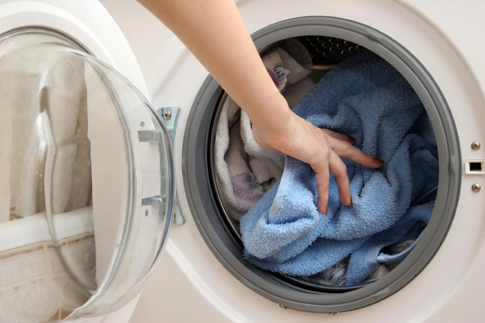 Women putting clothing into a dryer