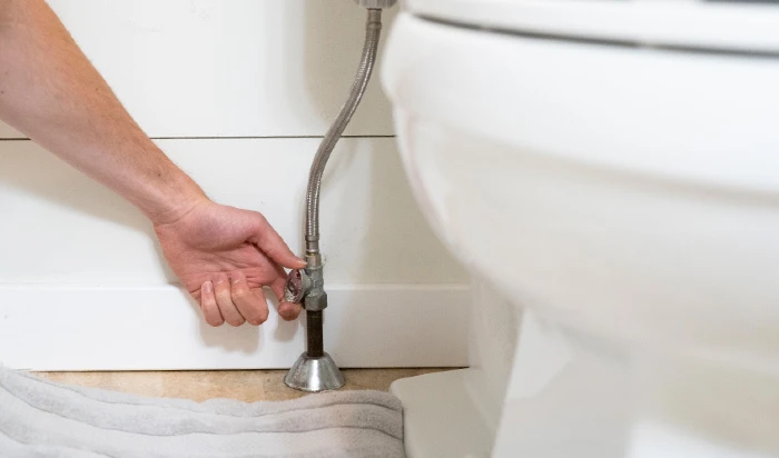 Plumber fixing a toilet