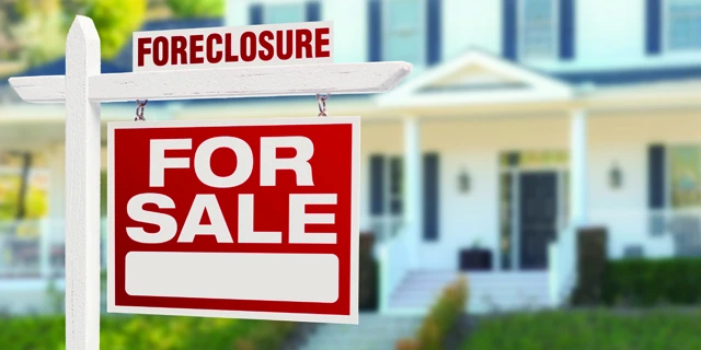 Foreclosure for sale sign in front of home