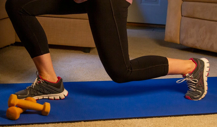 Woman exercising at home on a yoga mat
