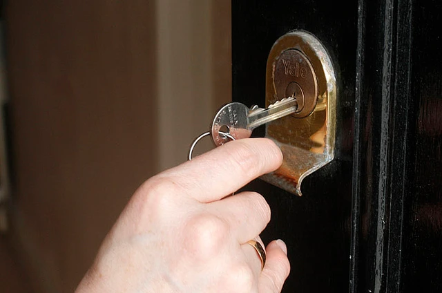 Person locking a door with a key