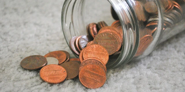 change jar with pennies falling out of it