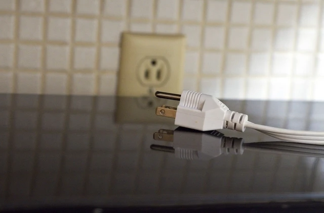 Plug laying on a counter by an outlet.