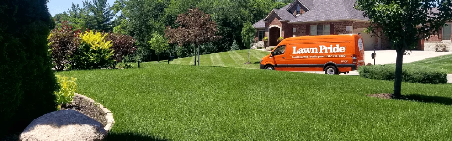 Lawn Pride van parked in front of lush grass.