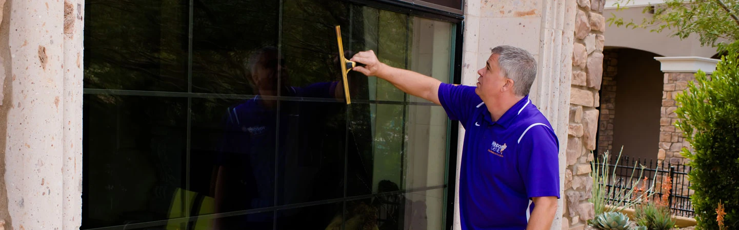 Window Genie employee squeegeeing a window