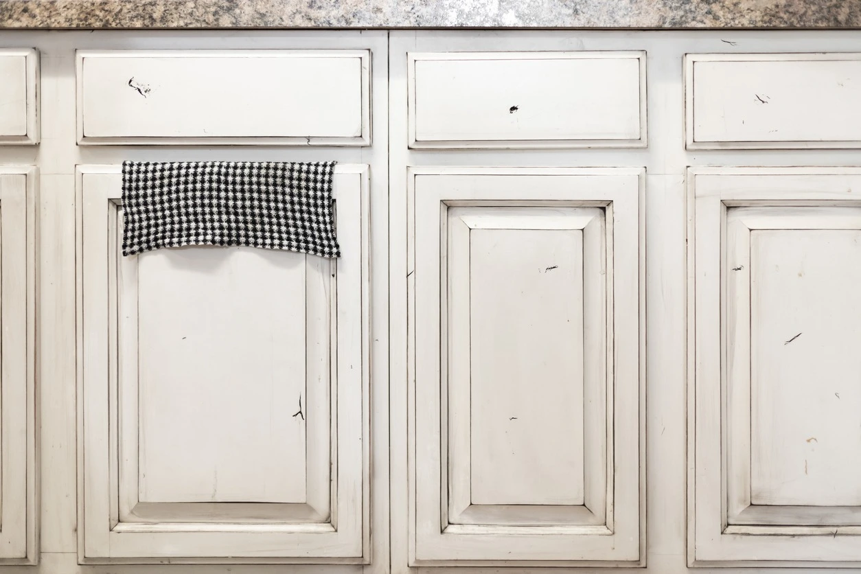 White painted and distressed kitchen cabinets.