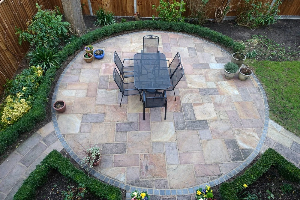 View of gorgeous circular patio with chairs and table after installation.