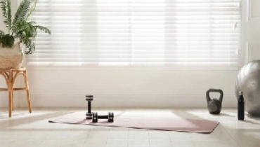Home gym with weights in front of bright window.