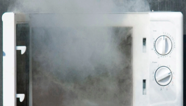 Overheating microwave with smoke coming out of it
