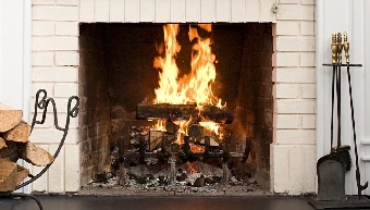 Burning fireplace with brick surround.