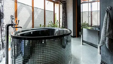 Glass tiled soaking tub in modern bathroom