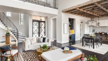 Panorama view of luxury home interior with open concept floor plan featuring living room, dining room, kitchen, and entry, with an elegant staircase leading to second floor