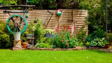 Beautiful home garden in full bloom located in backyard of residential home with a privacy wall.