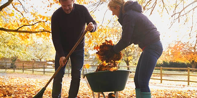 man and woman raking leaves.