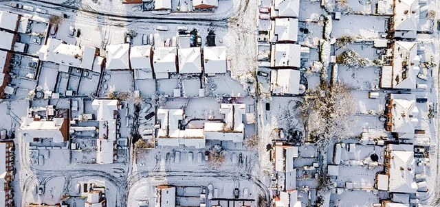 Overhead view of neighborhood homes in snow.