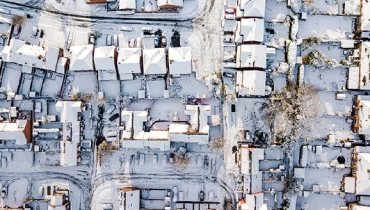 Overhead view of neighborhood homes in snow.