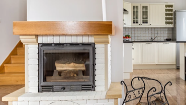 White brick fireplace with wood mantel.