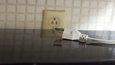 Plug laying on a counter by an outlet.